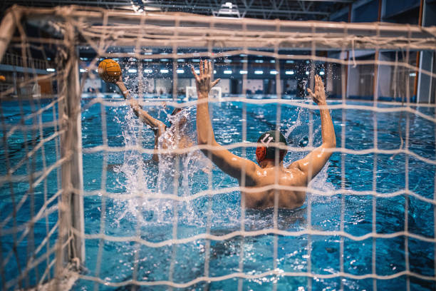 istock Man scoring a goal in water polo match 1208345926