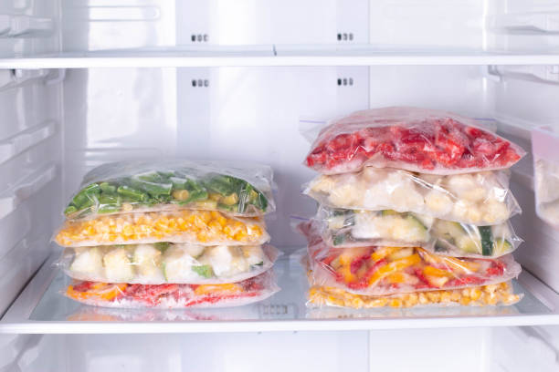istock Plastic bags with deep frozen vegetables in refrigerator 1208345943
