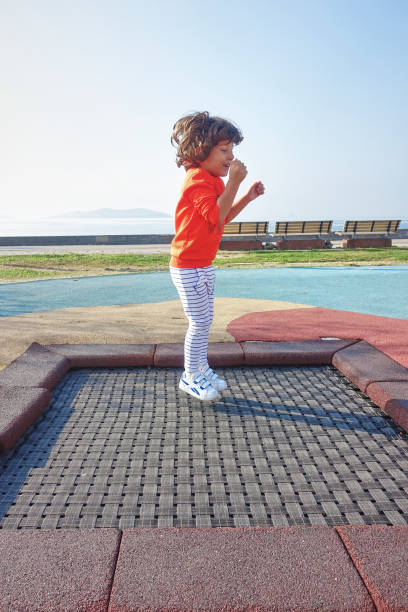 istock Happy little boy plays outdoors jumping on trampoline 1208346061