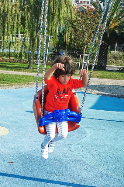 istock Happy laughing little boy in swing on playground 1208346316