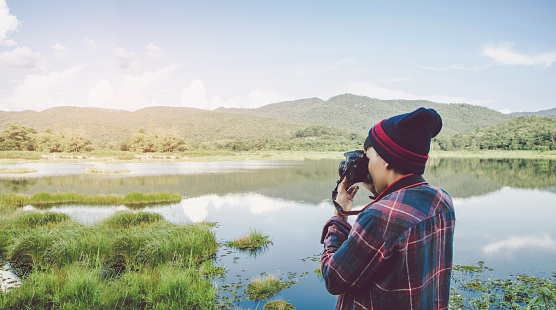 The Asian photographer using Camera DSLR, Digital Single Lens Reflex takes a photo Mountain  river landscape. Traveling Concept. Hiker concept.