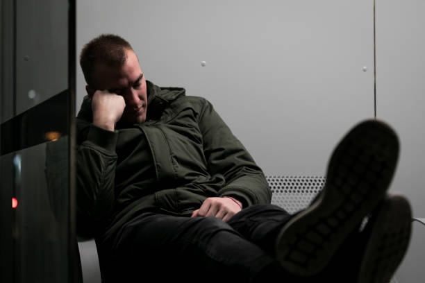 istock Tired young man waiting for a train at night 1208347528