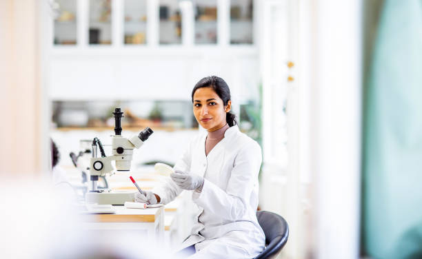 verticale d’un scientifique dans le laboratoire - microscope laboratory scientist women photos et images de collection