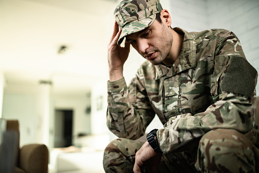 Un joven soldado del ejército sintiéndose deprimido y pensando en algo. photo