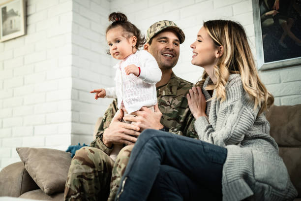 Happy military family enjoying in time together at home. Low angle view of happy military family relaxing at home. uniform photos stock pictures, royalty-free photos & images