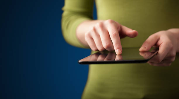 istock Close up of hand holding digital touchpad tablet device 1208349322