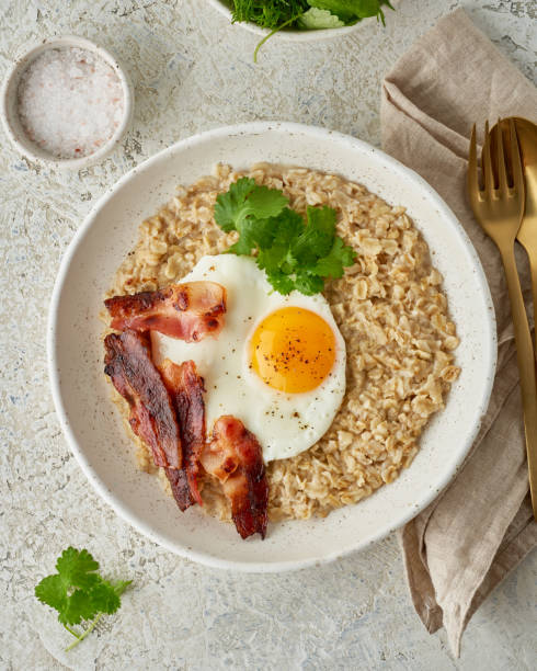 istock Oatmeal, fried egg, fried bacon. Intuitive conscious food, vertical 1208349907