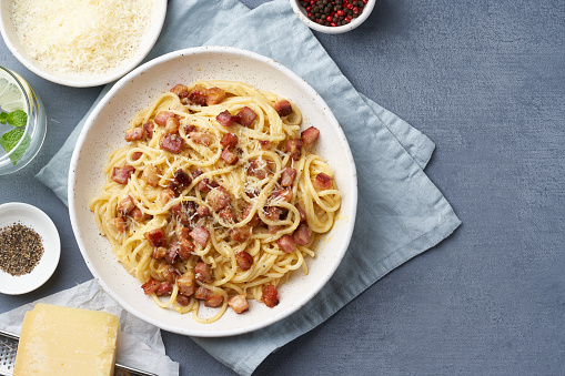 Carbonara pasta. Spaghetti with pancetta, egg, parmesan cheese and cream sauce. Traditional italian cuisine. Top view, copy space