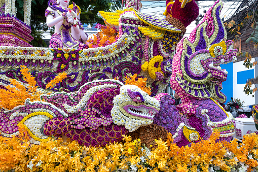A colorful floral float depicting angels and mythical animals in an annual flower festival parade in Chiang mai, Thailand.