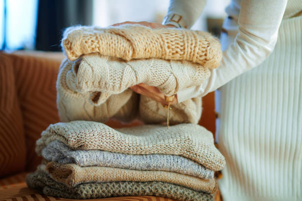 primer plano en la mujer cerca de suéteres plegables sofá para almacenamiento - plegar fotografías e imágenes de stock