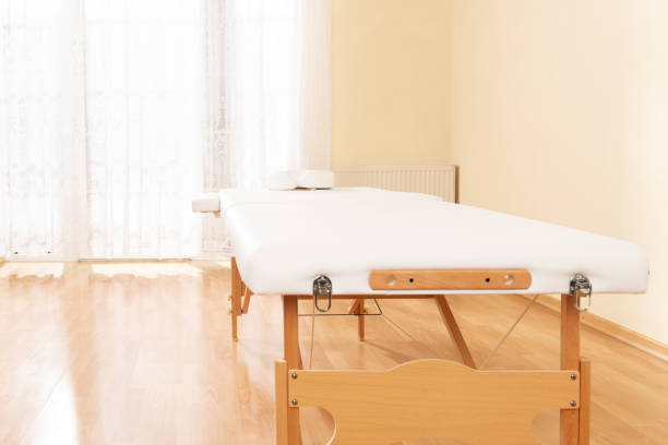 istock Interior of a massage or physical therapy treatment room with examination table. 1208354675
