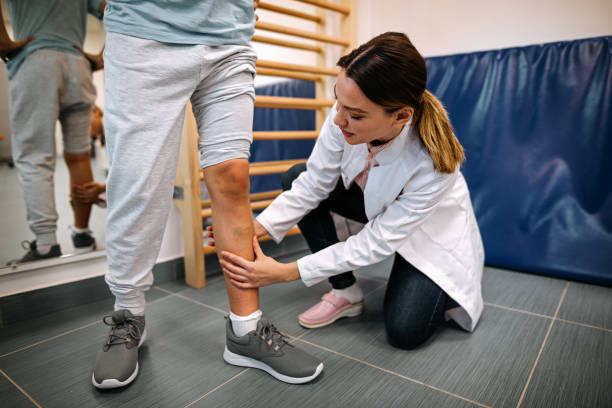 istock Female physical therapist examining leg muscle injury 1208354749
