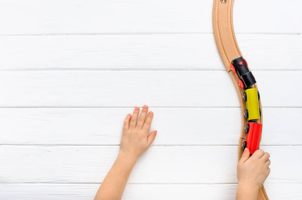 Child playing with wooden toy railway