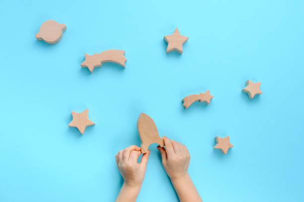 istock Child playing with wooden toys galaxy on blue background 1208354792