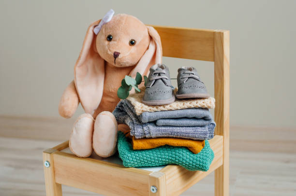 vêtements en coton organique sur la chaise d’enfants dans la salle d’enfants - baby clothing photos et images de collection