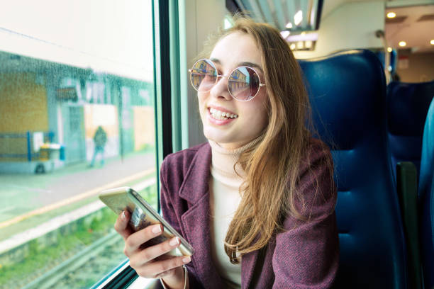 istock Young girl using smart phone in subway train 1208357649