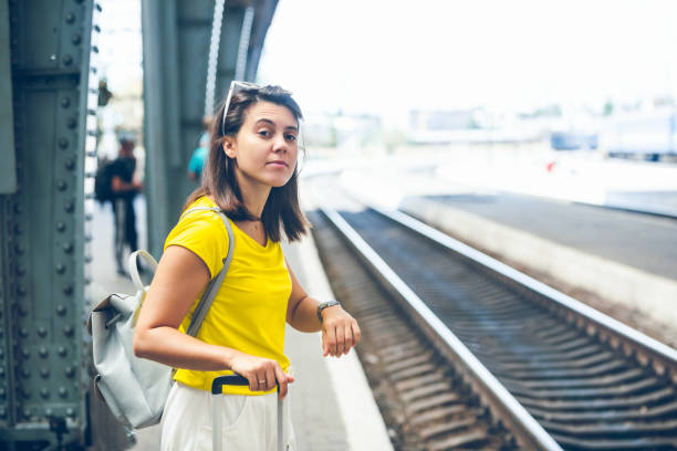 istock woman at railway station waiting for train 1208357658