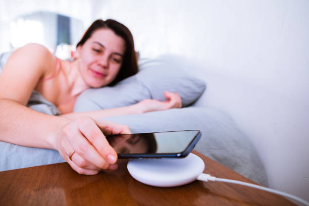 istock woman put cellphone for charging on wireless charge 1208357676