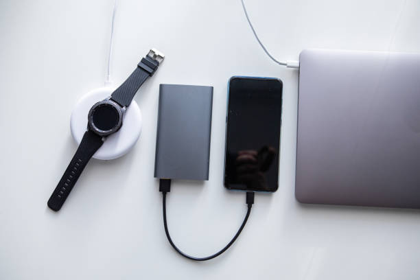 istock laptop with phone computer mouse and smart watch charging on wireless charger 1208357691
