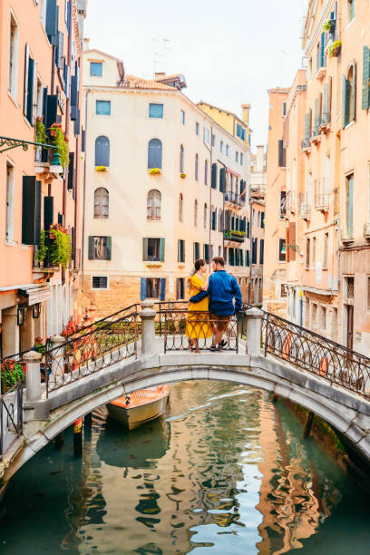 istock couple standing on the bridge crossing venice canals 1208357718