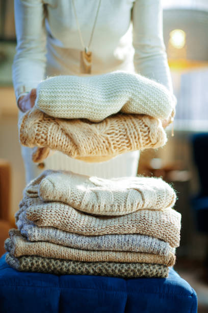 istock Closeup on housewife prepare sweaters pile for storage 1208358063