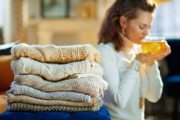 istock Closeup on sweaters and woman enjoying tea in background 1208358882