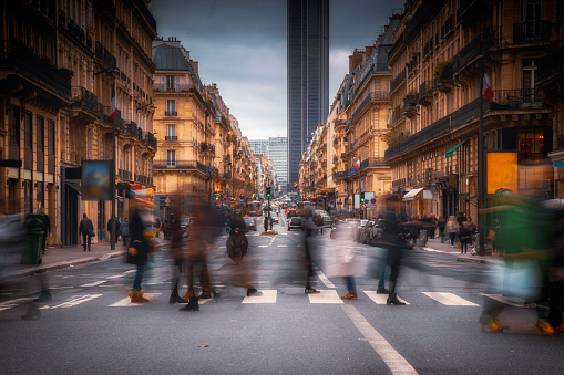 People are walking and crossing the street in Paris city centre