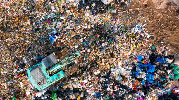 Photo of Ecosystem and healthy environment concepts and background, Garbage pile in trash dump or landfill, Aerial view garbage trucks unload garbage to a landfill, global warming.