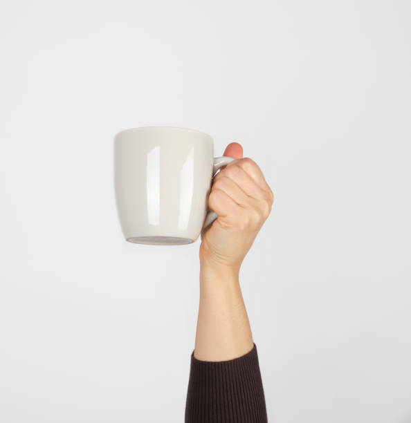 istock white ceramic cup in a female hand on a white background 1208359080