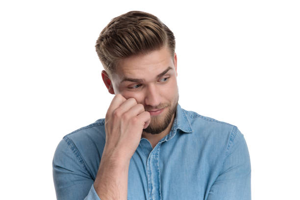 istock Wondering casual man looking away with hand on his face 1208361400