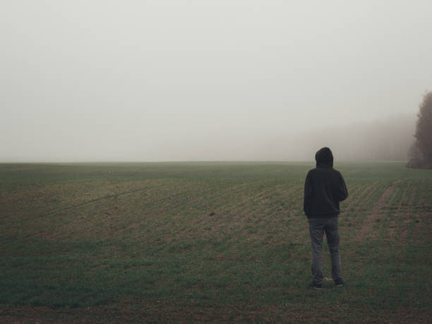 istock Alone man stands in an empty misty field. Autumn misty landscapes 1208361711