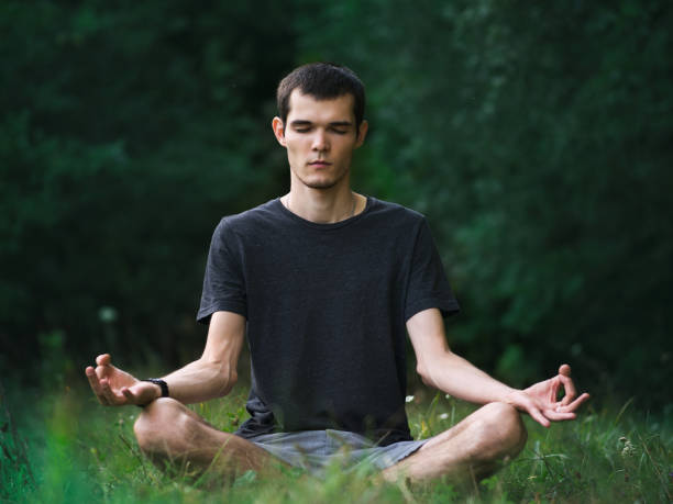 istock A young man sits in a Lotus yoga pose in a Park 1208361735