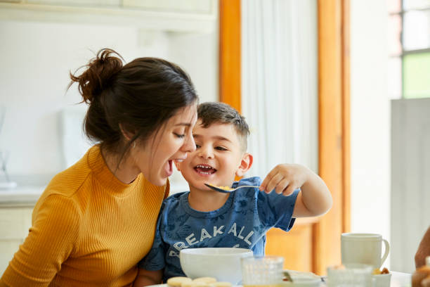 istock Happy son feeding breakfast to mother 1208363337