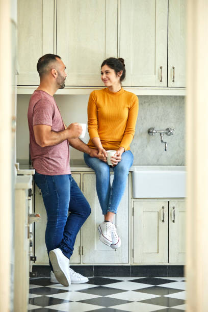 istock Man having coffee with woman at kitchen counter 1208363338