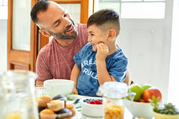 istock Smiling father and son having breakfast at home 1208363372