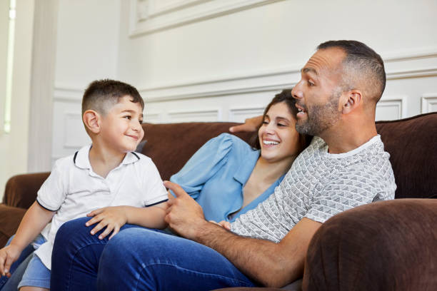 istock Smiling son with parents on sofa at home 1208363413
