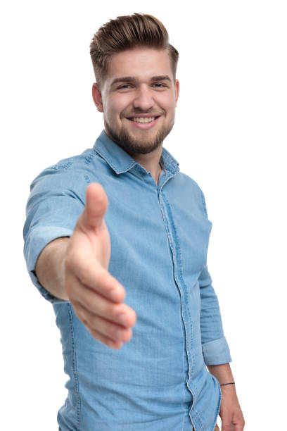 istock Positive casual man smiling and reaching for a handshake 1208363425