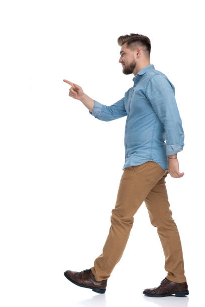 istock Side view of a confident casual man pointing and smiling 1208363971