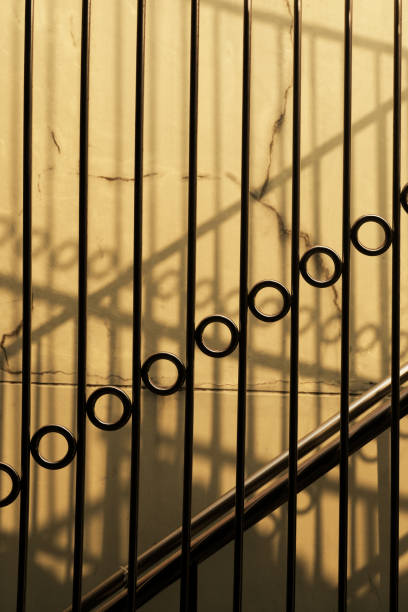 istock vertical metallic fence shadow on concrete wall architecture background 1208366916