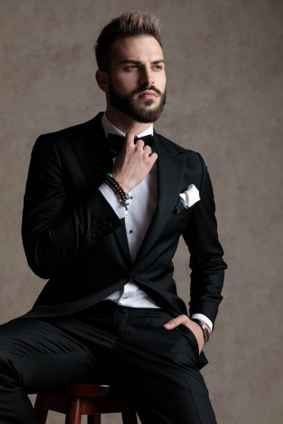 istock Serious groom fixing his bowtie and looking away 1208366970