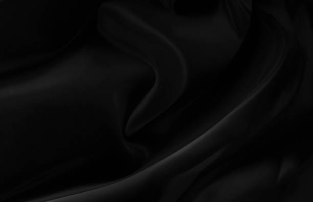 istock Black gray satin dark fabric texture luxurious shiny that is abstract silk cloth background with patterns soft waves blur beautiful. 1208367124