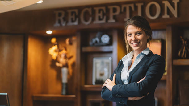 Confident receptionist with arms crossed at the hotel reception