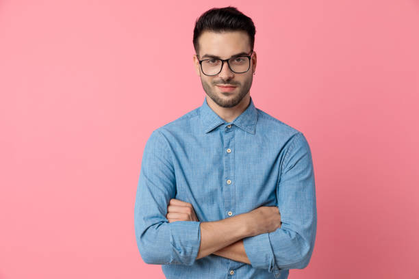 istock smiling young man crossing arms on pink background 1208370154