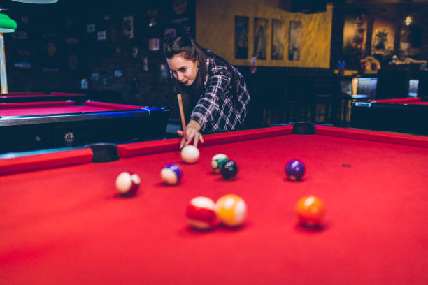 istock Young woman aiming at pool ball 1208371004