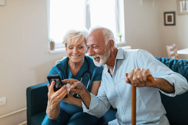 istock Mature nurse spending time with happy elder patient in nursing home 1208371124