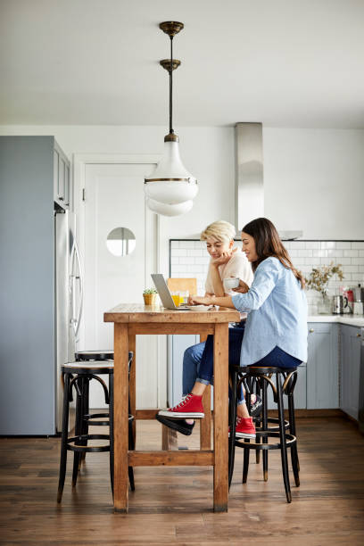 istock couple using laptop in kitchen at home 1208371231