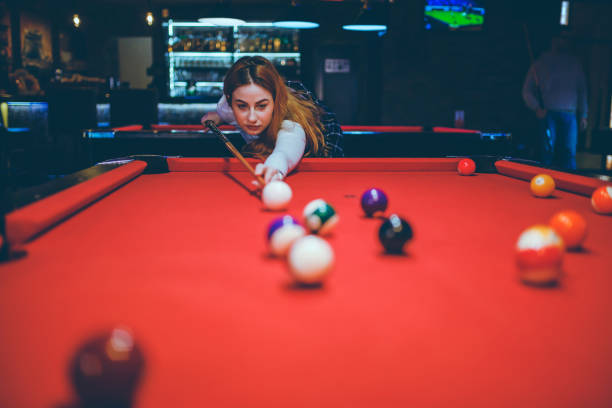 istock Young woman aiming at pool ball 1208372014