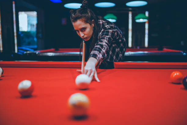 istock Woman aiming and playing pool in the bar 1208372308