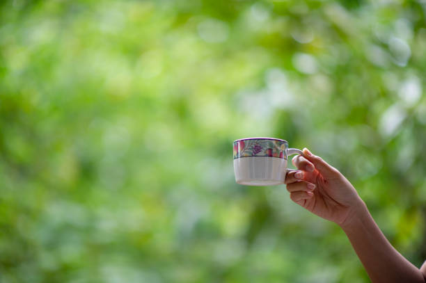 Hand and hot coffee mugs in the morning. Drink ideas.
