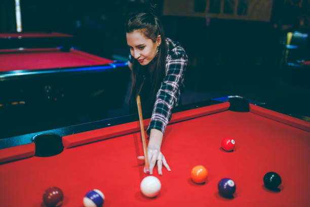 istock Young woman aiming at pool ball 1208372856